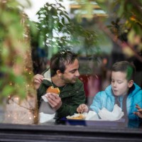 father and son having discussion and lunch at fast food restaurant - junk food stock pictures, royalty-free photos & images