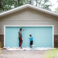 father and son painting garage door together - home decoration stock pictures, royalty-free photos & images
