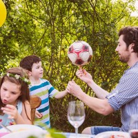 father and son playing with soccer ball on a garden party - garden decoration stock pictures, royalty-free photos & images