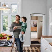 father and son using tablet in kitchen looking at ceiling lamp - home decoration stock pictures, royalty-free photos & images