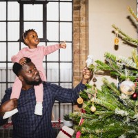 father and young daughter admiring christmas tree decorations - home decoration stockfoto's en -beelden