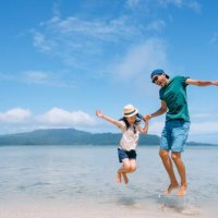 father and young daughter jumping on beach - travel stock pictures, royalty-free photos & images