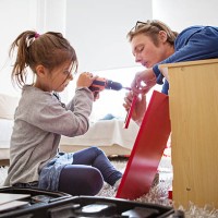 father helping daughter in making toy kitchen - home decoration stock pictures, royalty-free photos & images