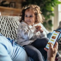 father ordering food online on the phone - junk food stock pictures, royalty-free photos & images