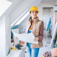 female architect looking at blueprints on construction site - home decoration stock pictures, royalty-free photos & images