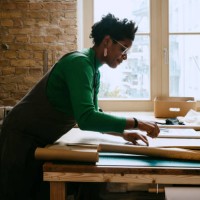 female artist concentrating while doing craft at table in living room - home decoration stock pictures, royalty-free photos & images