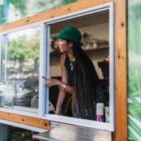 female barista looks outside food cart window - junk food stock pictures, royalty-free photos & images