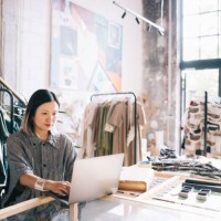 female clothing shop owner uses her laptop to manage orders - fashion stock pictures, royalty-free photos & images