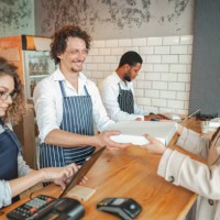 female customer buying pizza for takeout at the bar - junk food stock pictures, royalty-free photos & images