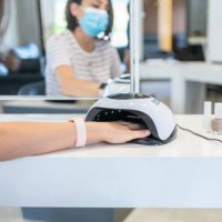 female customer putting hand i̇nto uv lamp dryer i̇n beauty salon - nails art stock pictures, royalty-free photos & images