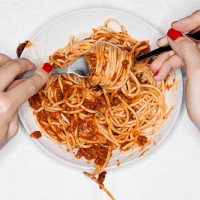 female eating spaghetti, overhead view - junk food stock pictures, royalty-free photos & images