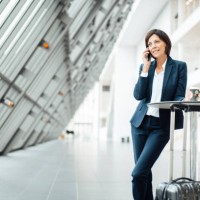 female entrepreneur with coffee cup talking on smart phone in corridor - junk food stock pictures, royalty-free photos & images