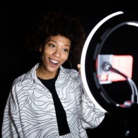 female fashion influencer filming against black background - fashion stock pictures, royalty-free photos & images
