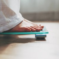 female feet standing on electronic scales for weight control on wooden background. the concept of slimming and weight loss - fashion stock pictures, royalty-free photos & images