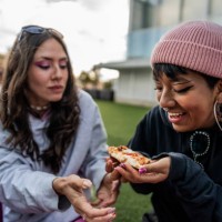 female friends eating pizza at the rooftop - junk food stock pictures, royalty-free photos & images