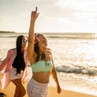 female friends having fun while walking on the beach - travel stock pictures, royalty-free photos & images