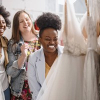 female friends looking at wedding dresses on rack - fashion stock pictures, royalty-free photos & images