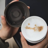 female hand holding a reusable coffee cup outdoor - junk food stock pictures, royalty-free photos & images