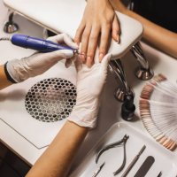 female hands while manicurist filing and polishing fingernails with professional device, making hardware manicure using electric machine in beauty studio. - nails art stock pictures, royalty-free photos & images