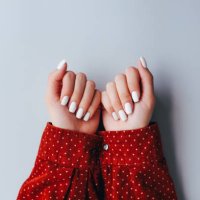female hands with white manicure on a gray background. skin care for hands, cuticles and manicure. beautiful nails. spa for hands. manicurist. - nails art stock pictures, royalty-free photos & images