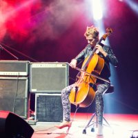 female musician playing cello on stage under spotlights - concert stock pictures, royalty-free photos & images