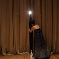 female peeking through curtains of concert hall stage,rear view - concert stock pictures, royalty-free photos & images