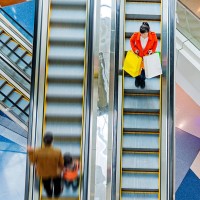 female shopper standing on escalator - fashion stock pictures, royalty-free photos & images