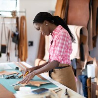 female small business owner working in her leatherwork studio - fashion stock pictures, royalty-free photos & images