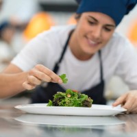 female student at a gourmet institute finishing the details of a salad she just made - food stock pictures, royalty-free photos & images
