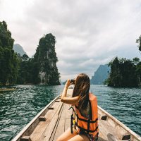 female tourist exploring lush jungle lake surrounded by limestone cliffs, khao sok national park, thailand - travel stock pictures, royalty-free photos & images
