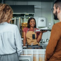 female worker giving orders to customers in a fast food restaurant - junk food stock pictures, royalty-free photos & images