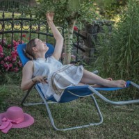 femme assise dans une chaise longue, se relaxant dans le jardin l’après-midi d’été - garden decoration photos et images de collection