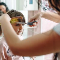 femme essayant de couper les cheveux de sa fille à la maison - hairstyle photos et images de collection