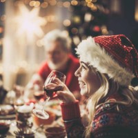 femme heureuse avec le père noël buvant du vin pendant le déjeuner de noël à la table à manger. - food photos et images de collection