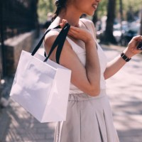 femme élégante utilisant un smartphone et transportant des sacs à provisions - fashion photos et images de collection