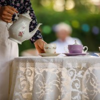 femme ramassant la tasse de thé pour servir à son mari pour le thé de l’après-midi - garden decoration photos et images de collection