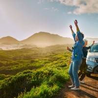 femmes d’âge mûr applaudissant près de leur voiture garée près d’une côte pittoresque lors d’un voyage en voiture - travel photos et images de collection