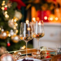 festive christmas dinner table with white wine glasses with roast goose turkey in cozy home - home decoration stock pictures, royalty-free photos & images