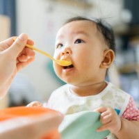 first meal dirty and messy asian mother try to feeding first meal for her daughter (2-6 month) at home - food stock pictures, royalty-free photos & images