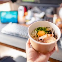 first person view with a paper bowl of ramen with egg york and char siu in front of desktop pc - junk food stock pictures, royalty-free photos & images