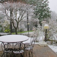 first snow, patio with table and chairs, meadow and trees - garden decoration photos et images de collection