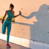fit woman stretching legs near wall - fashion stock pictures, royalty-free photos & images