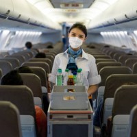 flight attendant serving drinks in an airplane wearing a facemask - food stock pictures, royalty-free photos & images