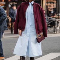 Flora Coquerel wears light blue shirt dress with matching tie, burgundy jacket, black lace tights, brown boots, burgundy bag, outside Casablanca,...