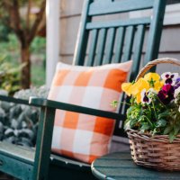 flower basket next to a green rocking chair - garden decoration stock pictures, royalty-free photos & images
