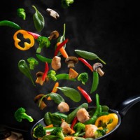 flying chicken and vegetable stir fry, into a frying pan - food stock pictures, royalty-free photos & images