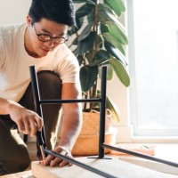 focused young man assembling furniture at home - home decoration stock pictures, royalty-free photos & images