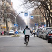 food courier person with thermal backpack on city street - junk food stock pictures, royalty-free photos & images