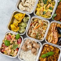 food delivery. сhinese takeaway food, italian food delivery. different aluminium lunch box with dumplings, noodles with chicken, rice with chicken, pasta with salmon, falafel - junk food stock pictures, royalty-free photos &
