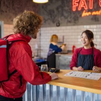 food delivery person at the fast food restaurant waiting to pick up the order - junk food stock pictures, royalty-free photos & images